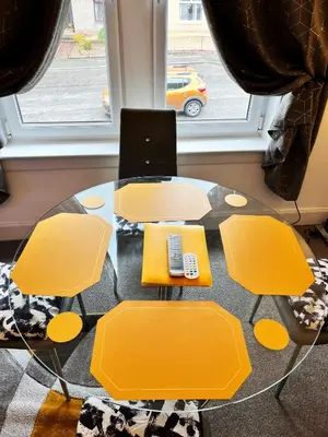 a glass table with yellow chairs and a laptop on it at 2 Bedrooms Entire Apartment Self Check in in Fife