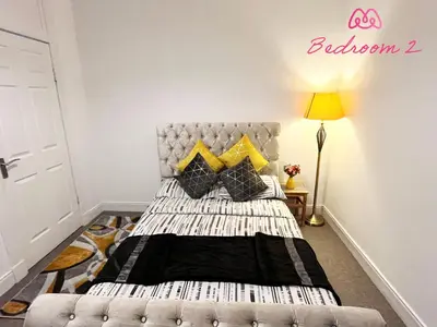 a bedroom with a bed with yellow pillows at 2 Bedrooms Entire Apartment Self Check in in Fife