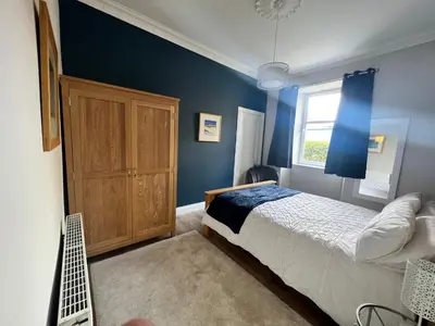 a bedroom with blue walls and a bed and a window at Number 79, Cosy Central Helensburgh 1 Bedroom, ground floor pet friendly, garden in Helensburgh
