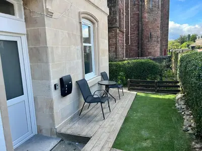 a patio with two chairs and a table on a house at Number 79, Cosy Central Helensburgh 1 Bedroom, ground floor pet friendly, garden in Helensburgh