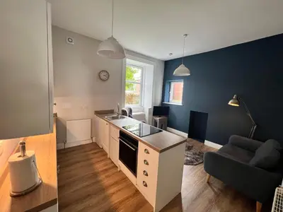 a kitchen with a counter and a couch in a room at Number 79, Cosy Central Helensburgh 1 Bedroom, ground floor pet friendly, garden in Helensburgh