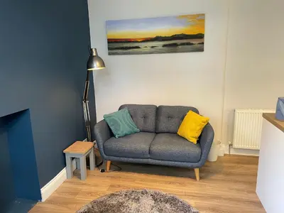a living room with a couch and a lamp at Number 79, Cosy Central Helensburgh 1 Bedroom, ground floor pet friendly, garden in Helensburgh