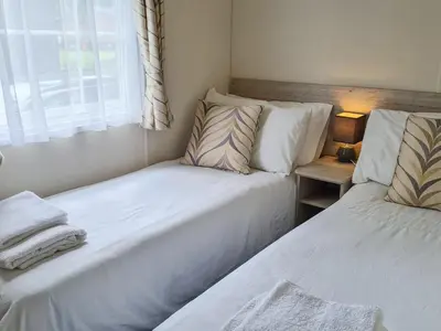 two beds in a small room with a window at Castle Campbell View in Dollar