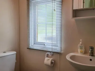 a bathroom with a toilet and a sink and a window at Castle Campbell View in Dollar