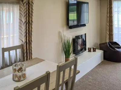 a dining room with a table and a tv on a wall at Castle Campbell View in Dollar