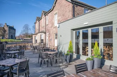 a patio with tables and chairs next to a building at The Woodside in Doune