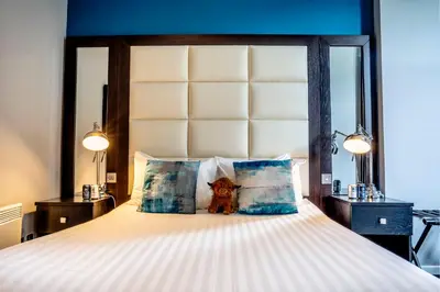 a bedroom with a large bed with two lamps at Colessio in Stirling