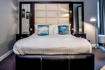 a bedroom with a large bed with a large headboard at Colessio in Stirling