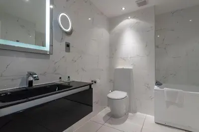 a white bathroom with a sink and a toilet at Colessio in Stirling