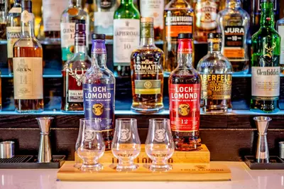 a bunch of bottles and glasses on a bar at Colessio in Stirling