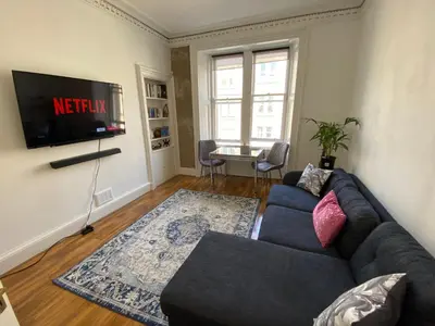 a living room with a couch and a tv at Traveller Award Winner 2024 - Edinburgh Apartment with 3 Beds in Edinburgh