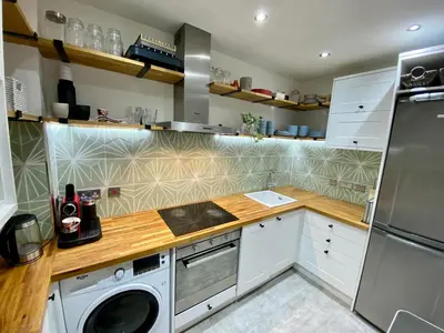 a kitchen with white cabinets and a washer and dryer at Traveller Award Winner 2024 - Edinburgh Apartment with 3 Beds in Edinburgh