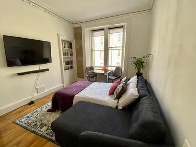 a bedroom with a large bed and a couch at Traveller Award Winner 2024 - Edinburgh Apartment with 3 Beds in Edinburgh