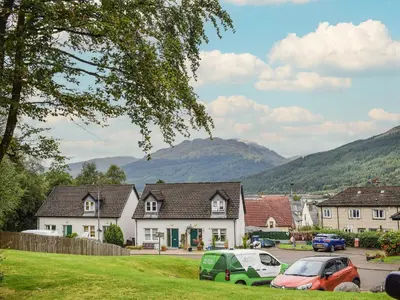 a village with cars parked in a parking lot at Beechwood in Arrochar