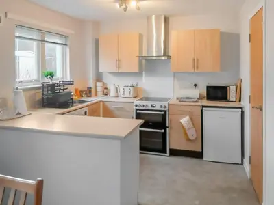 a kitchen with a stove and a microwave at Beechwood in Arrochar