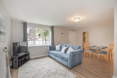 a living room with a couch and a tv and a table at The Nelson - Spacious City Property and Free Parking in Glasgow