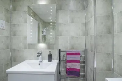 a bathroom with a sink and a mirror at The Nelson - Spacious City Property and Free Parking in Glasgow
