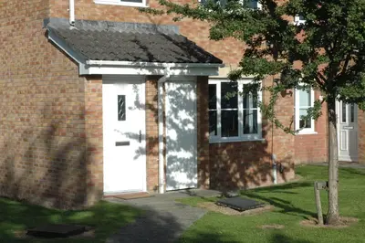 a white door on the side of a brick building at The Nelson - Spacious City Property and Free Parking in Glasgow