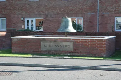 a bell in front of a brick building at The Nelson - Spacious City Property and Free Parking in Glasgow