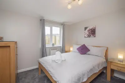 a bedroom with a white bed and a window at The Nelson - Spacious City Property and Free Parking in Glasgow