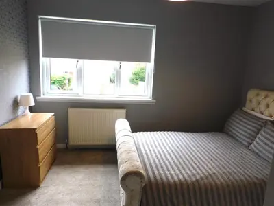 a small bedroom with a bed and a window at Beautiful 3 bedroom home with large garden 35 mins to Glasgow & Edinburgh in Whitburn