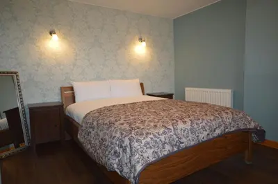 a bedroom with a large bed with two pillows at Ardura Apartment No 2 in Oban