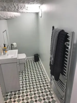 a bathroom with a sink and a black and white tile floor at 1Bed Golfhill Cottage in Dunblane