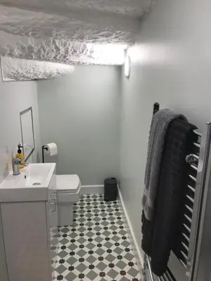 a bathroom with a sink and a black towel at 1Bed Golfhill Cottage in Dunblane