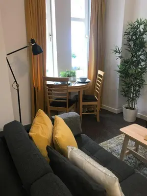 a living room with a couch and a table at 1Bed Golfhill Cottage in Dunblane