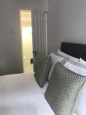 a white bed with two pillows on top of it at 1Bed Golfhill Cottage in Dunblane