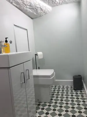 a white bathroom with a toilet and a sink at 1Bed Golfhill Cottage in Dunblane
