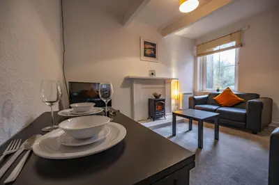 a living room with a table with two wine glasses at George Street Apartment in Oban