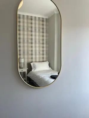 a bedroom with a bed and a mirror on a wall at The Haven in Greenock