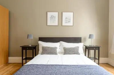 a bedroom with a large bed with two night stands at 2 Bed Old Town Apartment - Next To Castle in Edinburgh