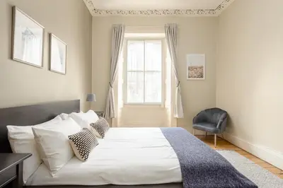 a bedroom with a large white bed and a window at 2 Bed Old Town Apartment - Next To Castle in Edinburgh