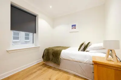 a bedroom with a bed and a flat screen tv at JOIVY Lovely Flats near the City Centre in Edinburgh