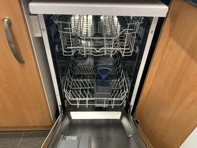 a dishwasher with its door open next to a cabinet at JOIVY Adorable flat near West End in Edinburgh