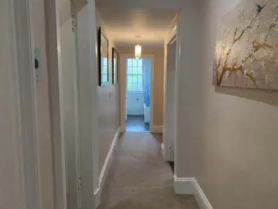 a hallway with white walls and a painting on the wall at JOIVY Adorable flat near West End in Edinburgh