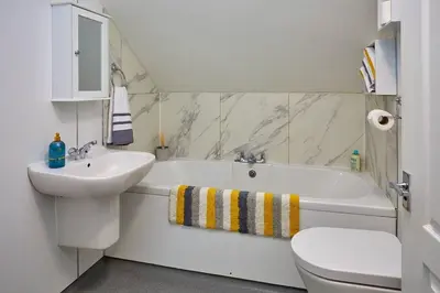 a bathroom with a sink and a tub and a toilet at Campbells Loft in Oban
