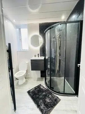 a bathroom with a glass shower and a toilet at Spacious 3 Bedroom Entire Apartment Self Check in in Fife
