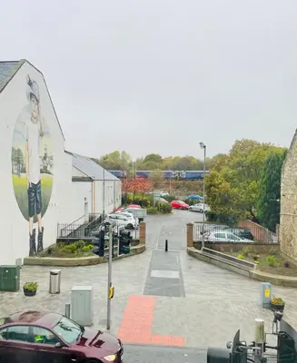 a parking lot with a large mural of a woman at Spacious 3 Bedroom Entire Apartment Self Check in in Fife