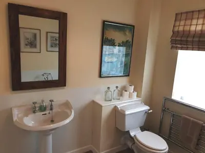 a bathroom with a sink and a toilet and a mirror at Lochs Lodge, Glenlyon, Perthshire in Bridge of Balgie