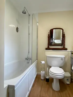 a bathroom with a toilet and a tub and a mirror at Lochs Lodge, Glenlyon, Perthshire in Bridge of Balgie