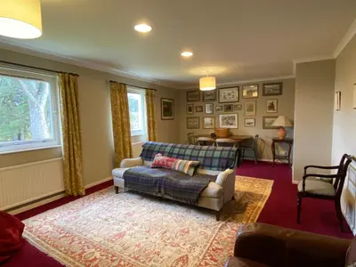 a living room with a couch and a table at Lochs Lodge, Glenlyon, Perthshire in Bridge of Balgie