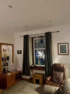 a living room with a chair and a window at 4B Millhill Street in Dunfermline