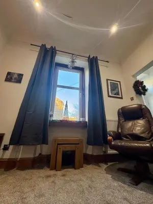 a living room with a chair and a window at 4B Millhill Street in Dunfermline