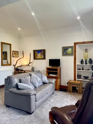 a living room with a couch and a tv at 4B Millhill Street in Dunfermline