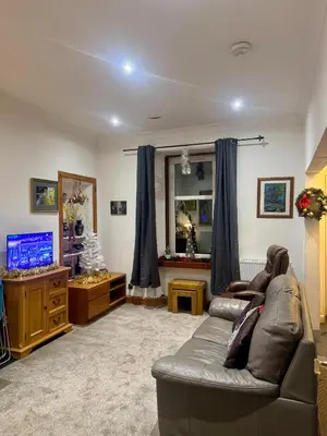 a living room with a couch and a mirror at 4B Millhill Street in Dunfermline
