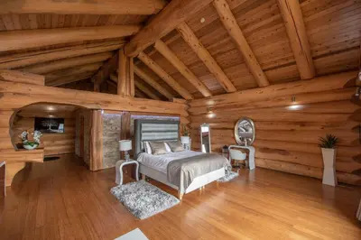a bedroom in a log cabin with a bed and a desk at The Log Cabins at The Vu in Bathgate