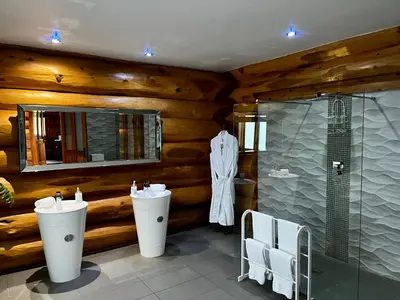 a bathroom with two sinks and a shower at The Log Cabins at The Vu in Bathgate